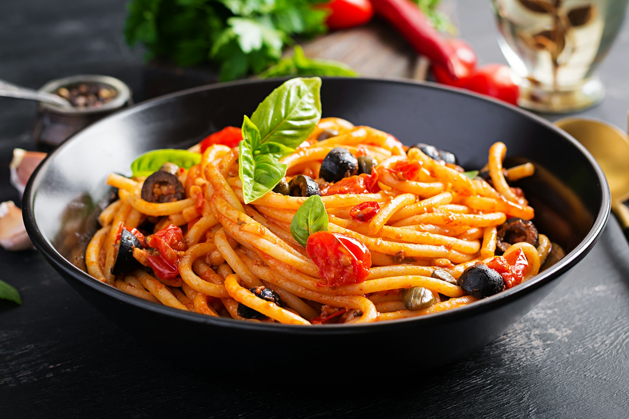 Spaghetti alla puttanesca - italian pasta dish with tomatoes